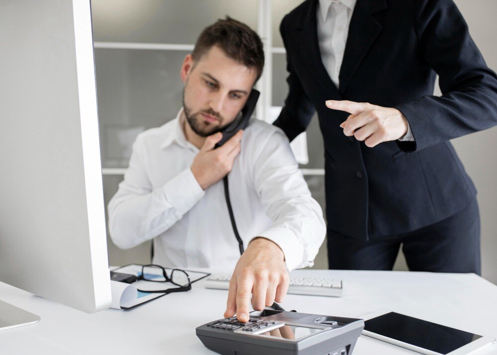 Homem no telefone com outro homem apontando o dedo para o mesmo