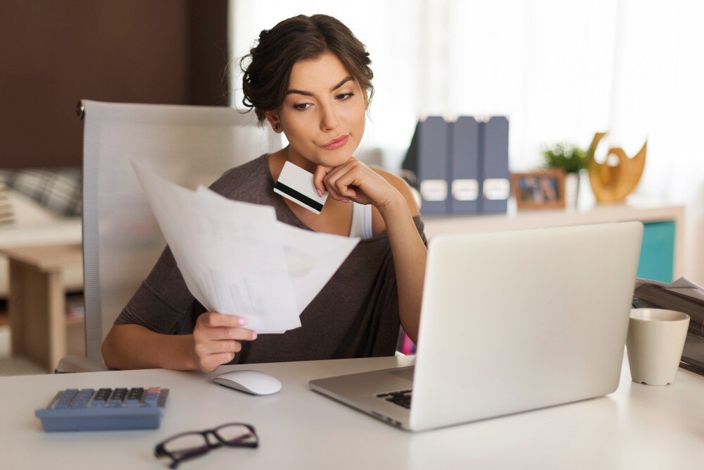 mulher mexendo no notebook conferindo a pontuação de crédito