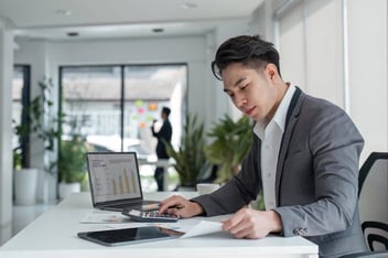 Homem mexendo no notebook pesquisando ferramentas de cobrança