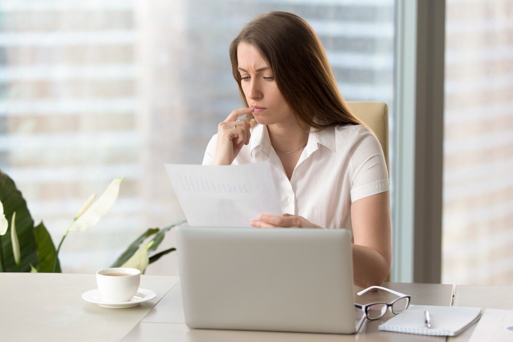 Mulher checando índice de inadimplência em notebook