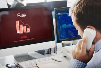 Homem analisando o risco financeiro em computador